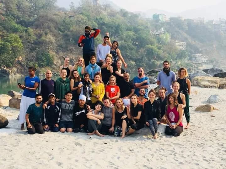 Graduating Deep Yoga cohort photographed together on the western bank of the Ganges in Rishikesh